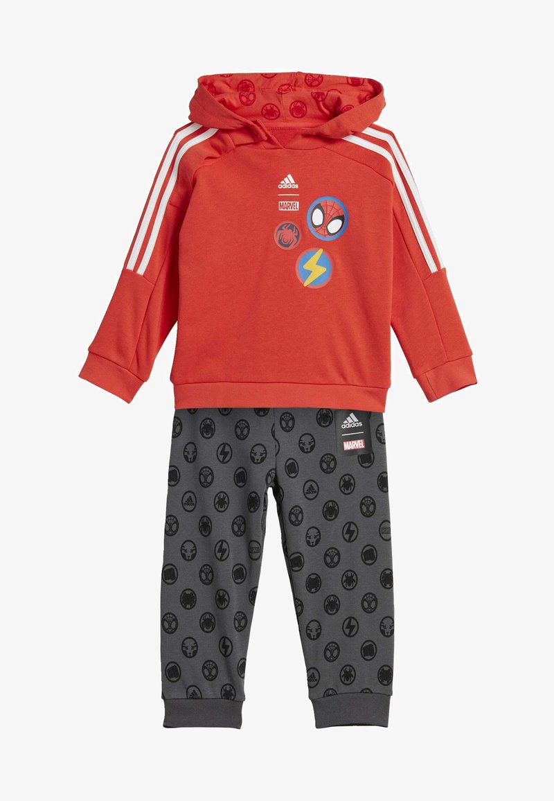 Felpa rossa con cappuccio e strisce bianche, decorata con grafiche Marvel, abbinata a pantaloni grigi con icone circolari nere dei supereroi.