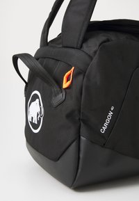Black fabric duffel bag with textured surface, logo featuring an elephant, orange clip detail, and a contrasting black base.