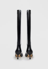 Stivali alti neri con tacco in materiale lucido, caratterizzati da punta affusolata e tacco a stiletto, con una texture liscia e dettagli minimi.