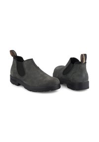 Botas Chelsea de cuero gris oscuro con paneles laterales elásticos, una tira de agarre y una suela de goma negra texturizada. Acabado liso con punta redondeada.