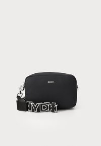 Black DKNY bag with a rectangular shape, smooth material, silver hardware, and a contrasting black and white logo strap. Zipper closure.