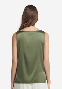 Satinowy, oliwkowozielony top bez rękawów o gładkiej teksturze, okrągłym dekolcie oraz prostych, czystych liniach na plecach i ramionach.