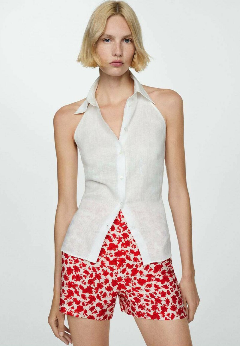 Bílá bezrukávová košile z lněného materiálu s knoflíkovým zapínáním, spárovaná s červenými šortkami s květinovým potiskem. Uvolněný střih a lehká textura.