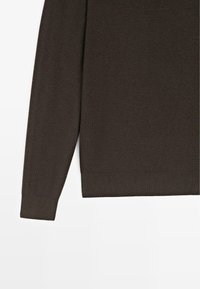Manica di maglione marrone scuro lavorato a maglia con texture a coste e polsini; presenta una finitura liscia e un design a taglio dritto.