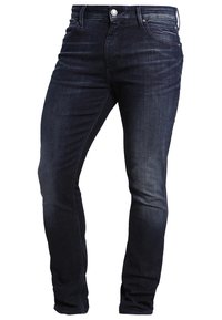 Tmavě modré džíny s úzkým střihem, hladkou texturou, pětikapsovým designem a jediným knoflíkovým zapínáním v pase. S vybledlými detaily.