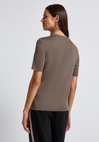 Brun kortärmad t-shirt med rund halsringning, tillverkad av mjukt och texturerat tyg. Har en ren och enkel design samt en regular fit.