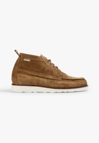 Chaussure décontractée en daim marron montant à la cheville, semelle blanche, fermeture à lacets et détails de coutures sur les côtés et le bout.