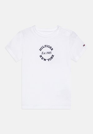 Fehér pamut póló, katonai kékre hímezett "HILFIGER NEW YORK Est. 1985" felirattal, kör alakú mintával. Nyomókával zárható váll.