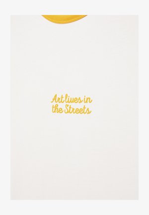 White fabric with yellow collar and yellow embroidered text "Art lives in the Streets" centered below the collar.