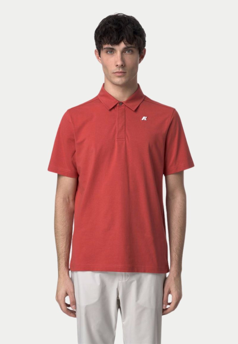 Polo rouge avec col, manches courtes et petit logo blanc sur le côté gauche de la poitrine. Fabriqué en tissu de coton lisse.