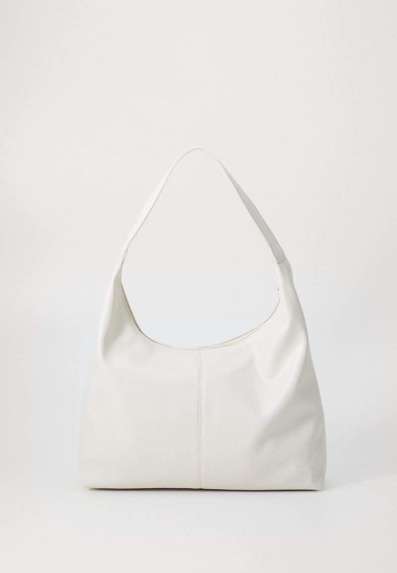 Sac à bandoulière en cuir blanc avec une forme douce et arrondie et une seule sangle large, présenté sur un fond clair uni.
