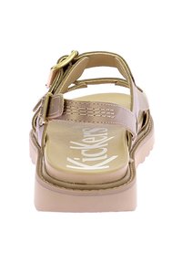 Beige sandal with a thick sole, adjustable strap, and logo. Features open heel and toe design for breathability. Smooth texture.