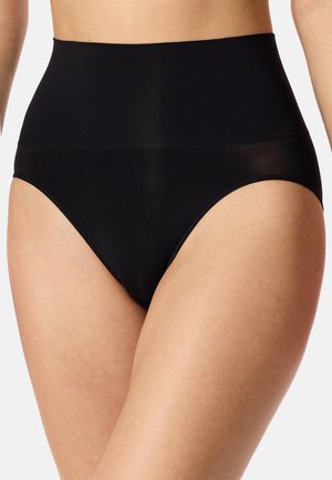 Schwarze hoch taillierte Shaping-Slips, getragen von einer hellhäutigen Person am unteren Oberkörper und oberen Oberschenkeln, vor einfarbigem Hintergrund gezeigt.
