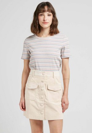 Chemise à manches courtes rayée dans des couleurs pastel, associée à une jupe en velours côtelé beige avec de grandes poches avant et des détails de boutons.