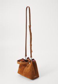 Brown suede handbag with a structured shape, adjustable leather strap, and red interior accents. Features a single handle and metal hardware.
