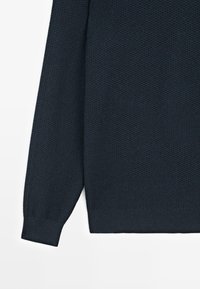 Maglione blu navy con trama, maniche lunghe, polsini a costine e orlo solido. Il tessuto presenta un motivo intrecciato per una maggiore profondità.