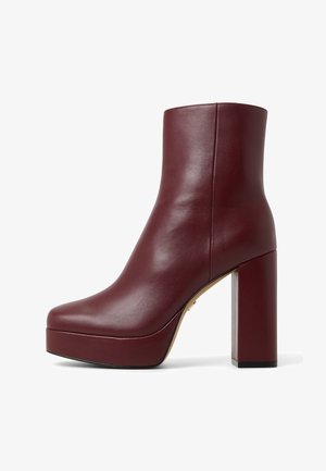 Bordeaux leren enkelboots met een gladde textuur, vierkante neus, hoge blokhak en platformzool, met een minimalistisch ontwerp.