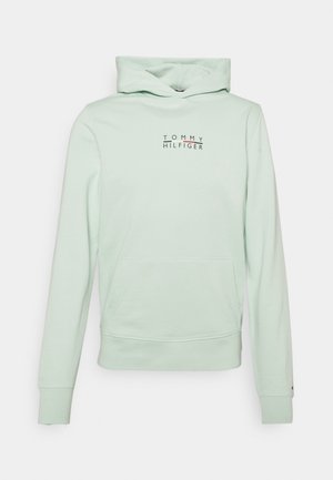 Lysegrøn hættetrøje med frontlomme og "Tommy Hilfiger" logo trykt med små bogstaver på brystet.