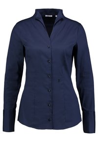 Granatowa koszula z długim rękawem, uszyta z gładkiego materiału, z kołnierzykiem, zapięciem na guziki oraz małym haftowanym detalem u dołu.