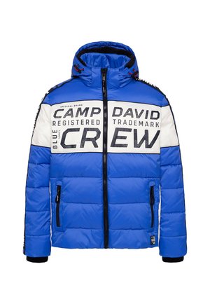 Blauer Puffer-Jacke mit abnehmbarem Kapuzen, großen Schwarz-Weiß-Schriftzügen, Reißverschlusstaschen, steppierter Textur und schwarzen Akzenten.