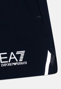 Shorts deportivos de color azul marino con logo blanco, detalles reflectantes y ventilación lateral. Tela suave con panel punteado para mayor transpirabilidad.