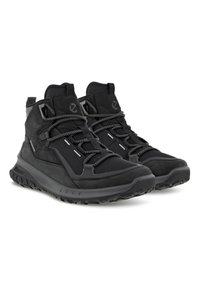 Le scarpe da trekking nere presentano una combinazione di materiali in rete e suede, una superficie testurizzata, lacci regolabili e suole in gomma robuste per garantire trazione.