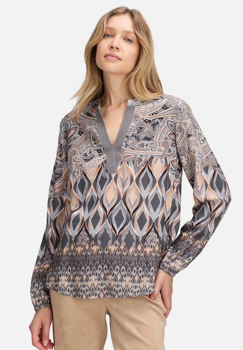 Bluzka z długim rękawem z wzorem paisley i geometrycznym w odcieniach szarości, beżu i pomarańczy. Dekolt w kształcie litery V z teksturowanym wykończeniem oraz luźny krój.