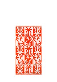 Tapis à motifs rouges et blancs avec des palmiers et des motifs animaliers dans des carrés alternés, avec une frange texturée le long d'un bord.