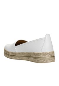 Une chaussure blanche à enfiler avec une tige en cuir texturé, dotée d'une semelle intermédiaire tissée évoquant le jute et de détails de couture subtils sur les côtés.