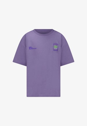 T-shirt violet à manches courtes avec col rond, portant un petit texte "KING OF THE PLAYGROUND" sur le côté gauche de la poitrine et un patch bleu-vert sur le côté droit de la poitrine.