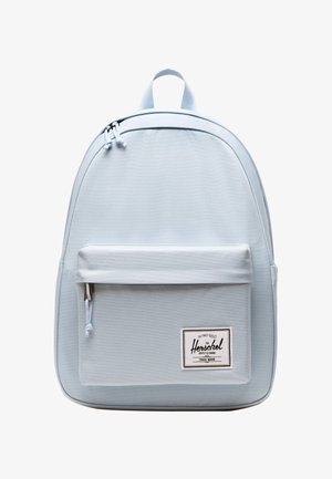 Lichtblauwe Herschel rugzak met een voorvak met rits en een stoffen merkembleem in de rechterbenedenhoek.