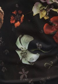 Μαύρο ύφασμα με λουλουδένιο μοτίβο σε ανοιχτό πράσινο, πορτοκαλί και μωβ λουλούδια. Η υφή είναι απαλή με διακριτική λάμψη.