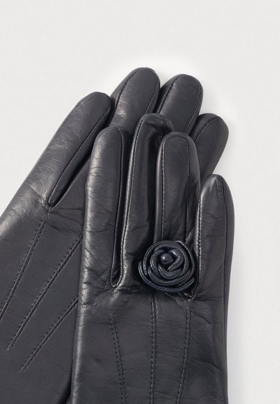 Μαύρα δερμάτινα γάντια με τριαντάφυλλο στη μανσέτα, με ραφές στο πίσω μέρος και λεία, υφή επιφάνεια.