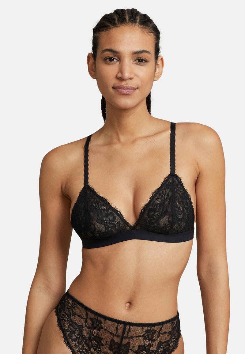 Czarny koronkowy stanik typu bralette z trójkątnymi miseczkami, regulowanymi ramiączkami i solidnym czarnym pasem. Charakteryzuje się skomplikowanym wzorem kwiatowym na całej koronce.