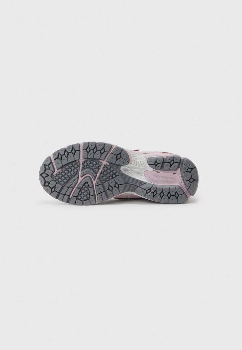 Semelle extérieure de chaussure de course rose avec une semelle en caoutchouc gris texturé. Présente des motifs de relief détaillés pour l'adhérence et le soutien, et un design léger.