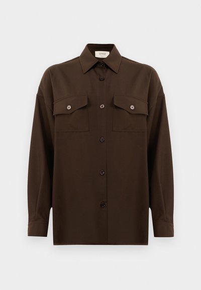 Chemise à manches longues brun foncé avec boutons, dotée de deux poches poitrine à rabat et d'un col classique, présentée sur un fond blanc uni.