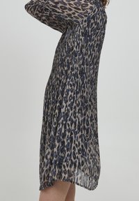 Plisserad klänning i lätt, genomskinlig tyg med ett grått, svart och blått leopardmönster, med långa ärmar och en avslappnad passform.