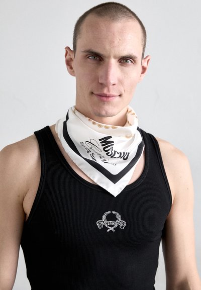 Zwarte geribbelde tanktop met een klein wit Moschino logo. Witte zijden bandana met zwarte accenten en bedrukte tekst, om de nek gewikkeld.