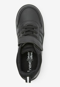 Chaussure noire pour enfants en cuir lisse, doublure en tissu texturé, sangle réglable et accents blancs sur la semelle.