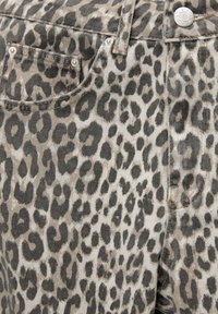 Los vaqueros de mezclilla con estampado de leopardo presentan un fondo beige con manchas marrón oscuro, cinco bolsillos y detalles en hardware plateado.