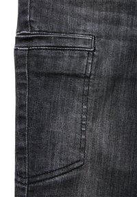 Ciemny dżins ma tylną kieszeń z estetycznym wykończeniem i subtelnym przeszyciem, podkreślającym gładką teksturę i klasyczny fason.