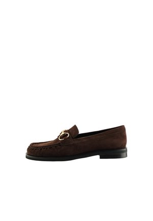 Brun ruskindslipper med guldfarvet hestebidsdetalje på toppen og en lav sort hæl, vist fra siden på en hvid baggrund.