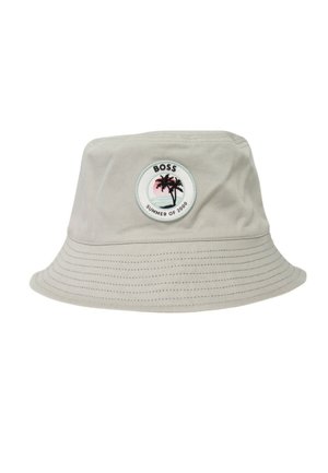 Cappello a secchiello beige chiaro con bordo cucito e toppa rotonda con due palme, tramonto e scritta "BOSS SUMMER OF 2000" sul davanti.