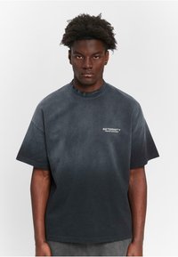 Oversized schwarzes Baumwoll-T-Shirt mit Rundhalsausschnitt und kurzen Ärmeln. Die Vorderseite zeigt weißen Text "RETERNITY CREATIVE DEPARTMENT". Glatte Textur.