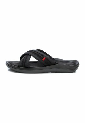 Chanclas negras con correas de costura cruzada, superficie texturizada y suela acolchada. Presentan un acento rojo en la correa.
