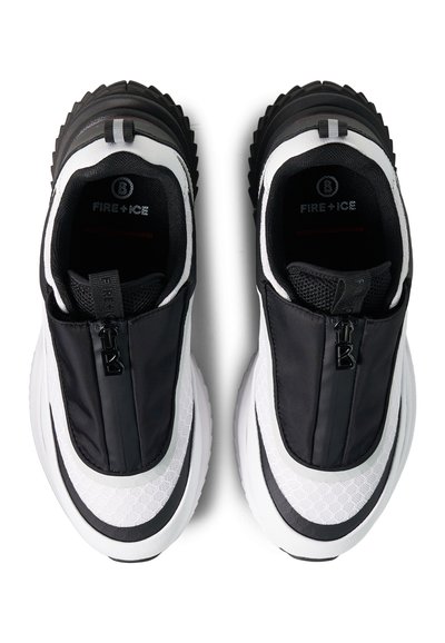 Paire de baskets slip-on noires et blanches avec dessus en mesh et cuir, fermeture éclair frontale, et semelles épaisses texturées vues de dessus.