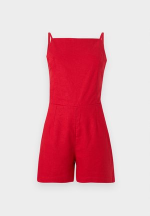 Red linen romper with thin straps, square neckline, and pleated front detail. Tailored fit with shorts, minimalistic design.