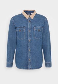 Camicia in denim blu con colletto in corduroy beige, chiusura con bottoni e due tasche sul petto con flap e chiusura a bottone.