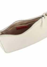 Borsa a busta in crema del brand Hugo, con esterno in pelle liscia, chiusura con zip in tonalità argento e interno beige con etichetta con logo.