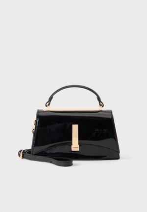 Sac à main noir brillant avec poignée supérieure, fermoir doré et bandoulière amovible sur fond clair uni.